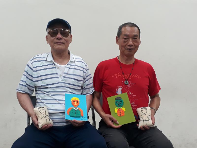 兩位男學員坐在椅子上分別展示自己的吊飾與黏土畫像