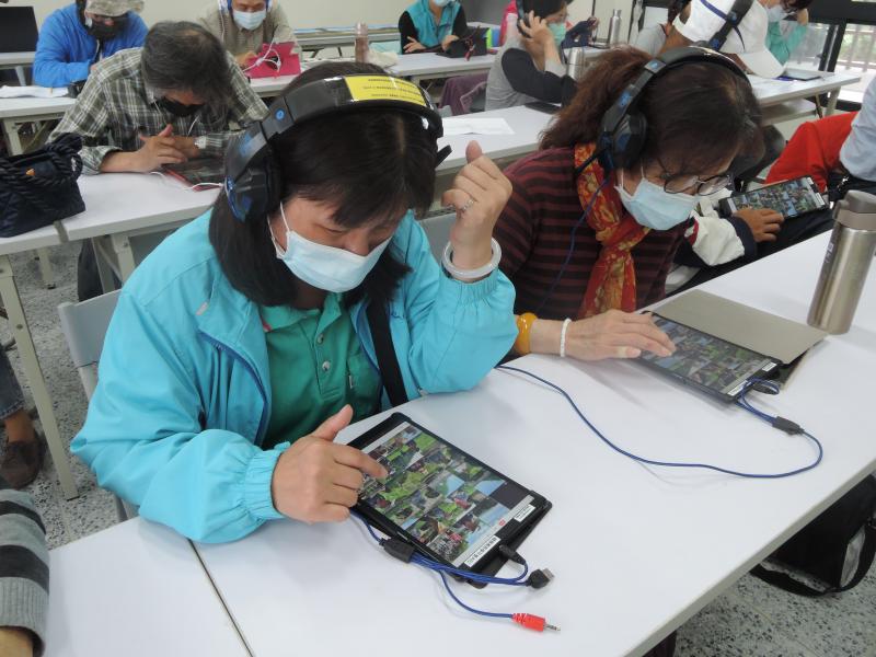 兩位女同學低著頭試著講師提供的素材按劇情組合為一部微電影