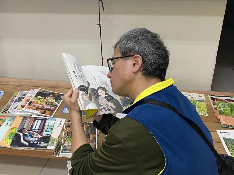 一位男同學看著老師帶來的雜誌