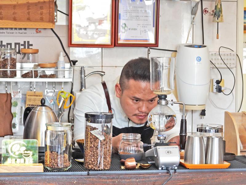 林菁川大哥正以虹吸式沖煮咖啡，聚精會神的神情，足以顯示氣度與專業。