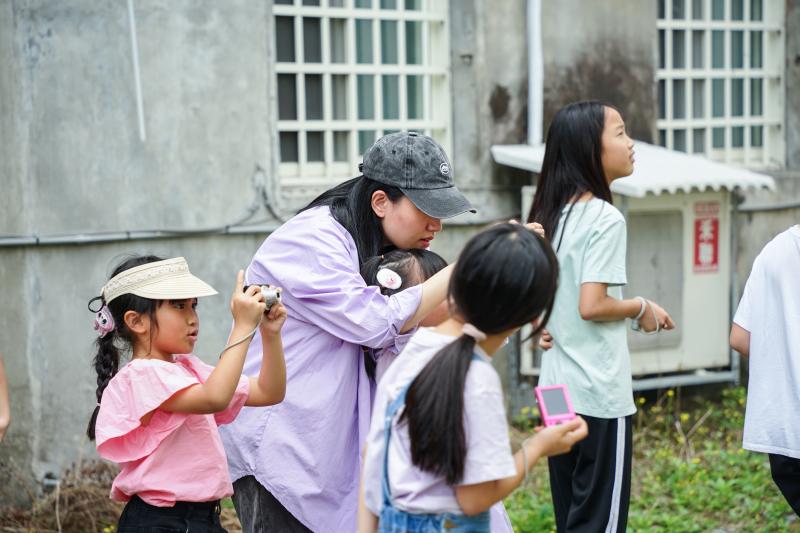 課程中家長與孩子共同調整畫面構圖，拍攝豐田街道上的風景