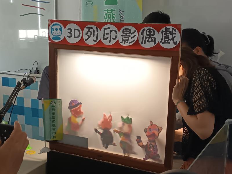 學員將完成的3D作品放到表演布幕後，測試色彩的飽和度。