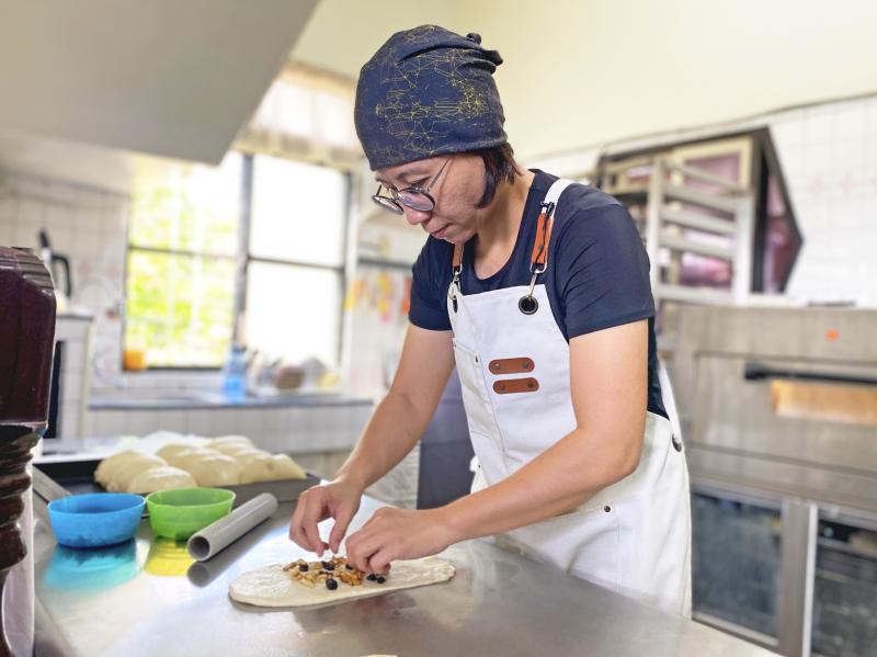 陳佳昀老闆娘正在把核桃、莓果加入麵團。