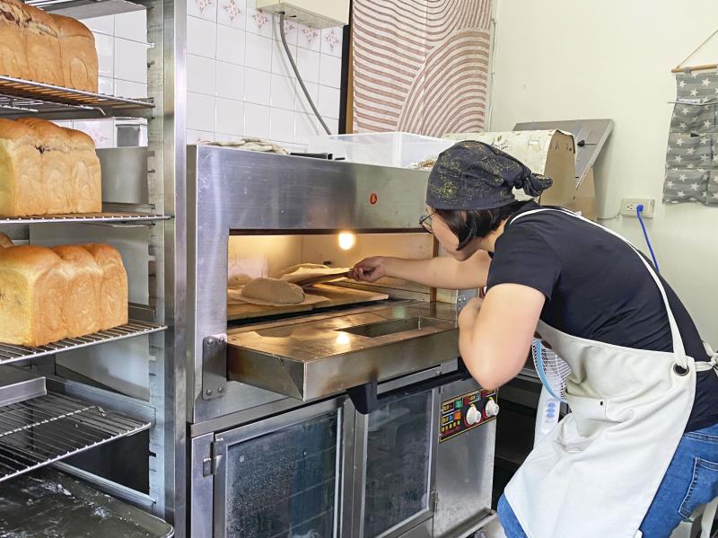 陳佳昀老闆娘正在檢查烤箱溫度以及麵包烘烤上色程度。