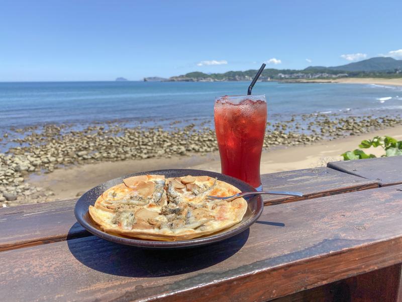 烏咪小巴的寮仔魚披薩，搭配清涼解渴的飲料，是欣賞海景的絕妙搭配。