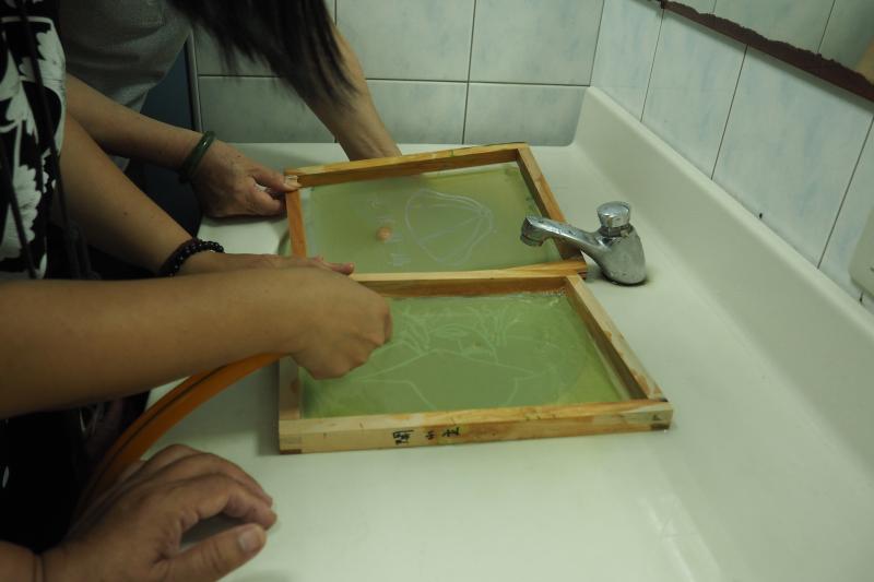 一邊用水沖一邊手摸網板上圖樣，兩面皆需要沖水，此時就可以看出圖樣 (沖洗力道不能過到大，避免圖樣失敗)