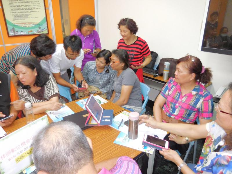 學員圍繞著講師聽著講師介紹APP的應用