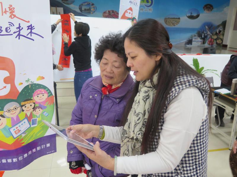 枋山DOC駐點人員指導現場長輩如何使用平板電腦上網挑選自己喜歡的春聯