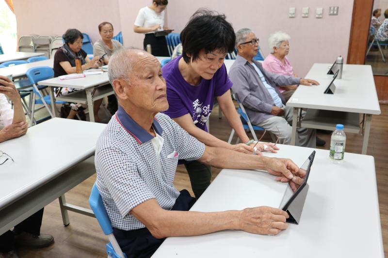志工協助阿公平板電腦操作使用