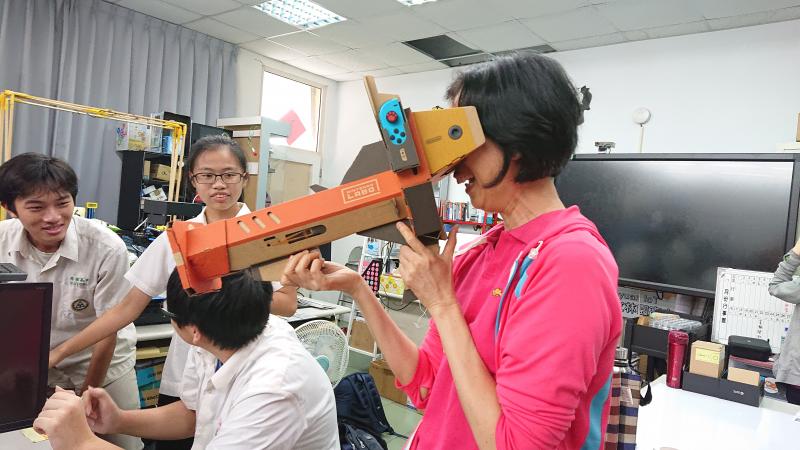 講師帶著學生志工一起分享VR體驗的互動小遊戲，學員體驗著前所未有的虛擬實境，開心玩著小遊戲。