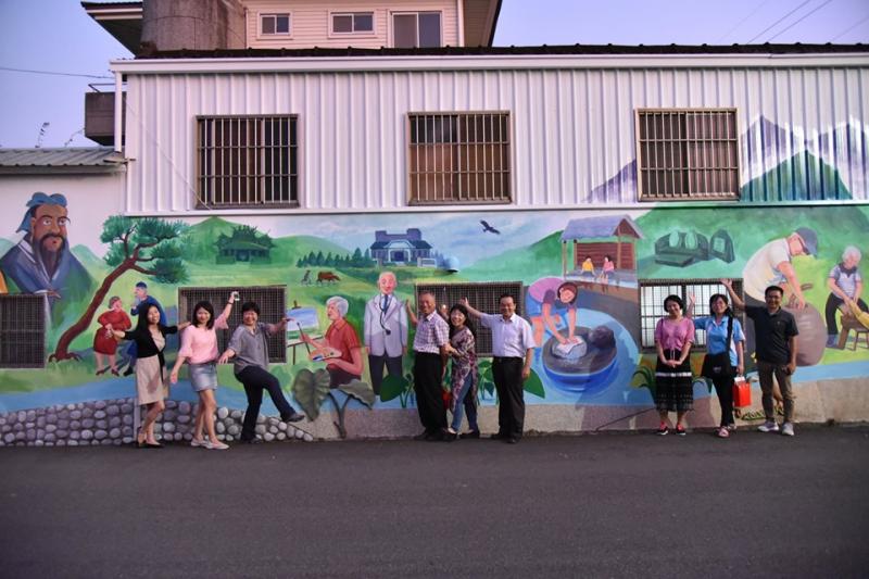 社區總幹事陪同教育部長官至石墻故事牆走逛。