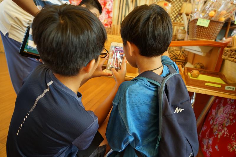 在地方文化典藏的實地課程中，小學員發揮創意，正在使用手機app的慢動作功能拍攝滾動的物體。