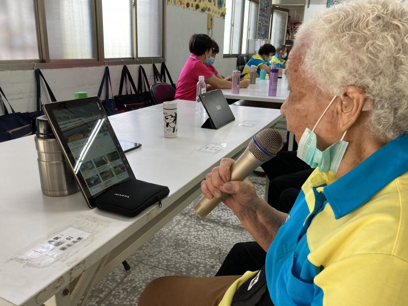 來到社區帶領學員們一起體驗平板應用，說了影音搜尋的功能後，近90歲的阿嬤，就這樣拿起了麥克風陶醉在自己的節奏裡。