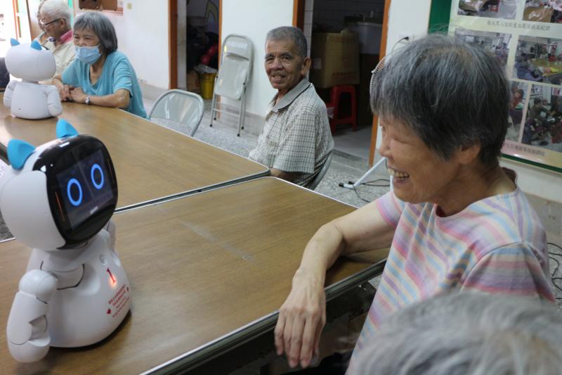 帶著機器人到社區關懷站，讓長輩們試試陪伴機器人，長輩們開心地和機器人對話。