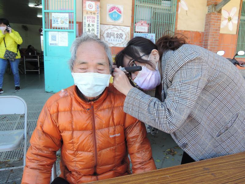 完成聽力檢測後，聽力師虹宇協助三灣長輩檢查耳朵狀況。