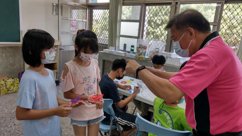 林中國小校長為小朋友作品拍照