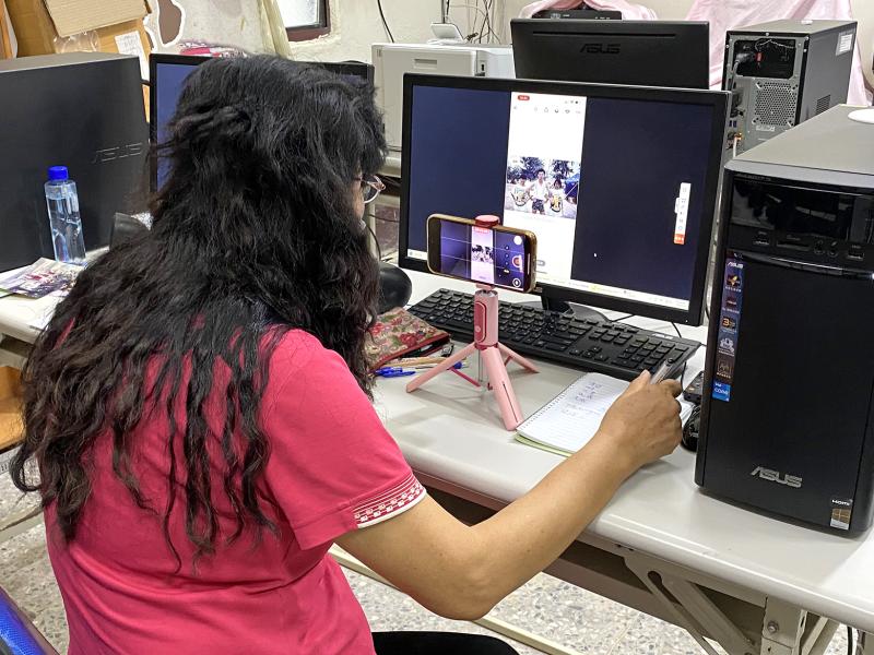 學員聚精會神地觀看講師示範如何運用AI技術修復與上色老照片，一邊仔細抄寫筆記，一邊以手機錄影紀錄操作步驟，盼能熟練掌握技術，為珍貴回憶注入新生命。