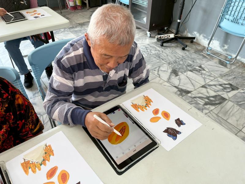 學員拿起平板時還有些猶豫，嘴裡不停說著「我袂曉畫啦」，老師教導如何畫畫後，學員手一拿起繪圖筆就認真投入，甚至畫出與老師所畫的木瓜很相似，看見學習的熱情和樂趣，數位畫畫年齡不是問題！