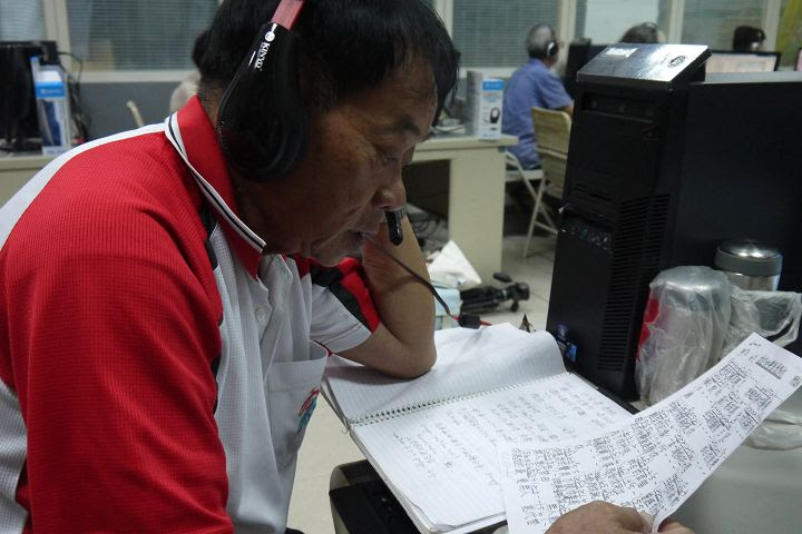 學員戴著耳麥就著歌詞努力排練