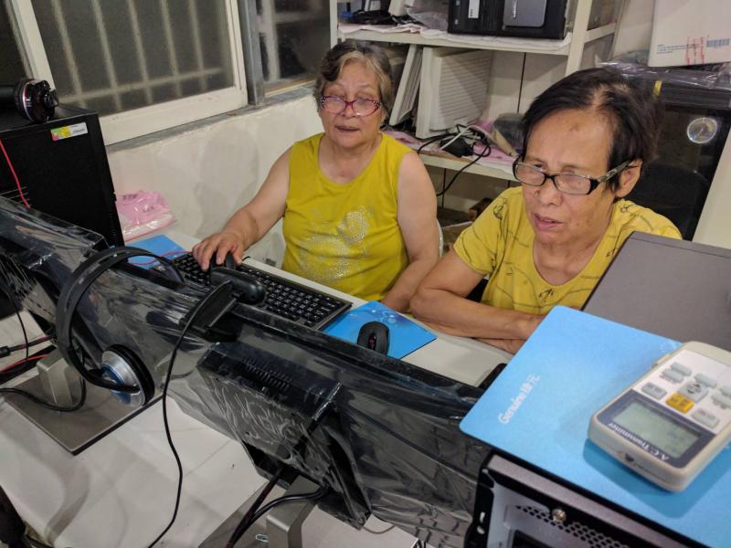 兩位婦女學員在電腦前聽講操作