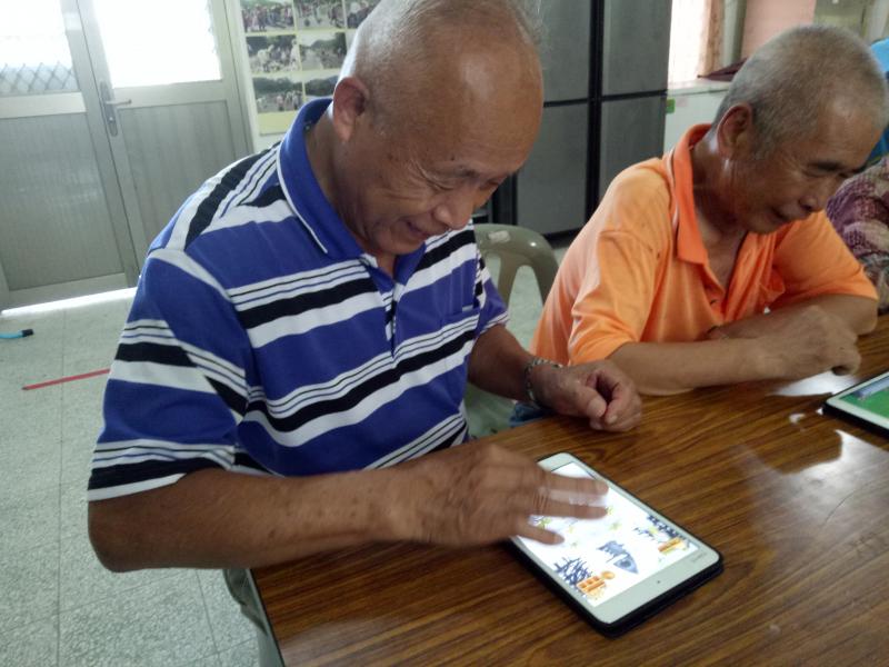 長輩慢慢的摸索平板的功能