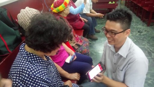 正在指導奶奶們，怎麼操作相機APP。