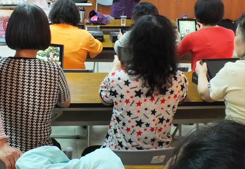 學員們手拿平板，認真依照講師教學步驟操作