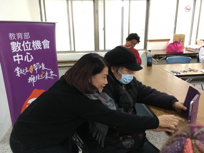 老師正在與學員們互動，學習如何使用平板。