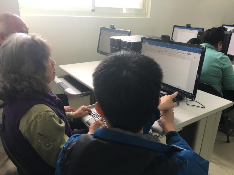 老師看著學員操作電腦