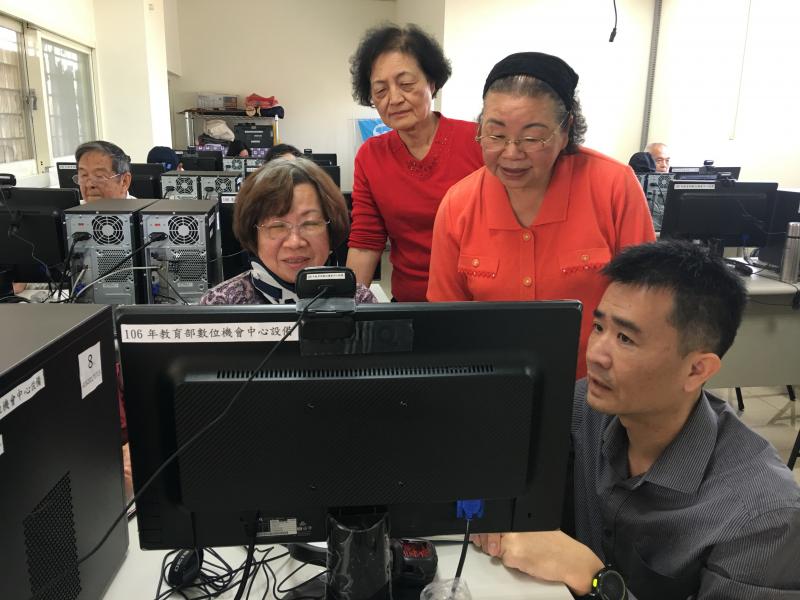學員們看著老師示範怎麼操作電腦