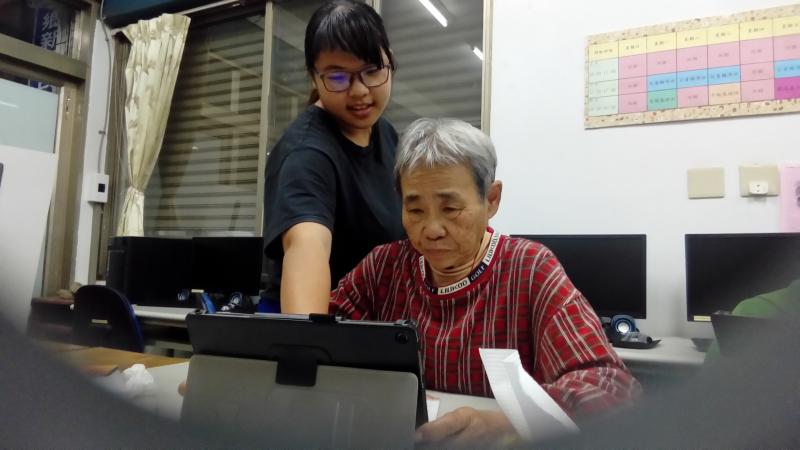 學員不熟悉操作，小志工同學陪著學員使用平板