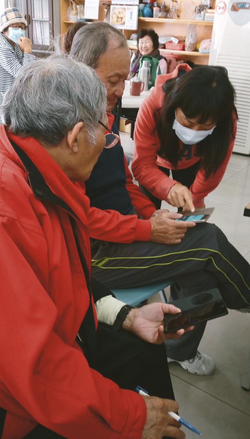 港東社區的志工指導爺爺使用APP