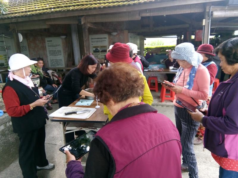 拿者平板，對者剛剛親手做出的成品，進行拍照，長輩覺得十分的有趣，等下就是大家一起分享的時間~