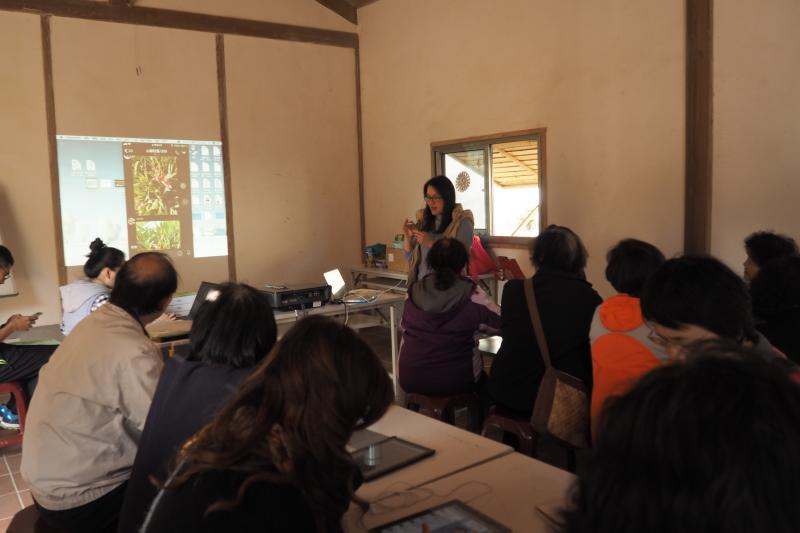 老師使用APP軟體「形色」拍攝植物花卉，投影給山腳社區民眾觀看並加解說這套軟體的功能