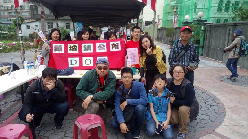 遊客福神弄龜的攤位前面拍照