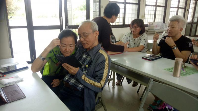 學員課餘時討論手機操作