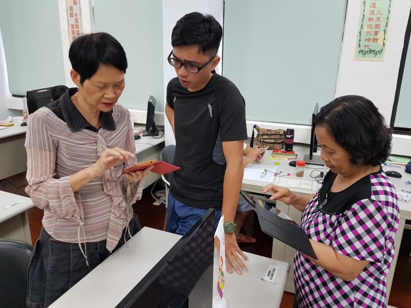 講師耐心教導學員操作手機