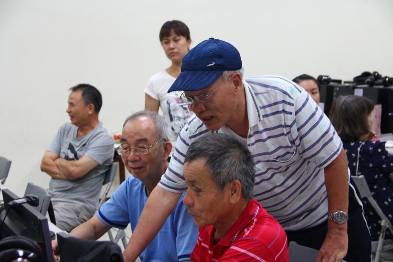 銀髮阿伯教另一個銀髮阿伯學員，如何修改桌曆的數字，名符其實的教學相長