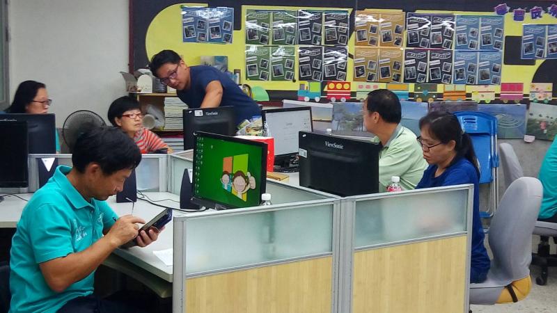 學員認真查農產品的資料，學員遇到問題請老師幫忙指導。