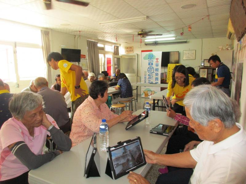 慈惠志工團志工們耐心協助長者們學習平板的使用方式