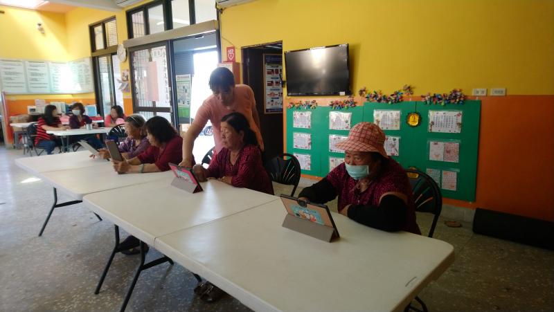 社區志工指導長輩操作