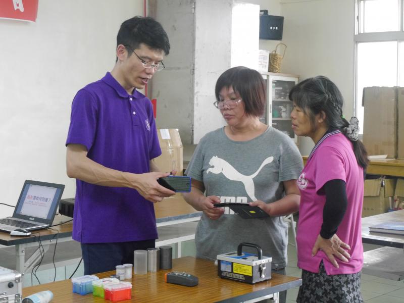 勇慶老師使用輻射偵測儀為銅鏡社區的學員偵測3C產品的數值