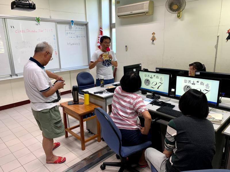 講師拿著範本展示給學員看，讓大家可以更明白我們要做什麼?