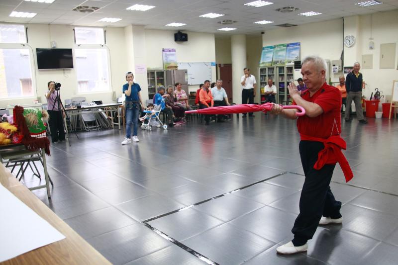 武師揮舞一把小紅傘，威風凜凜。