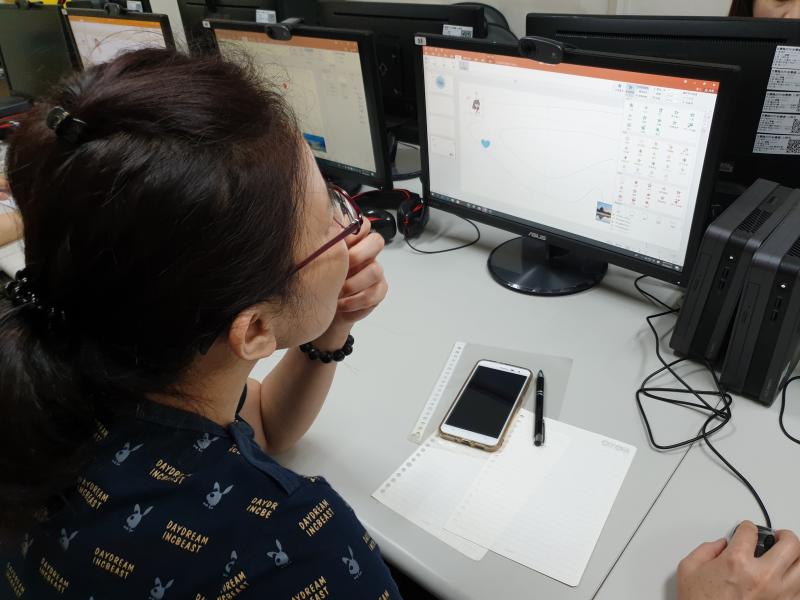 學員以左手撫摸下巴，雙眼直視空白的ppt投影片，思考要從何起手。