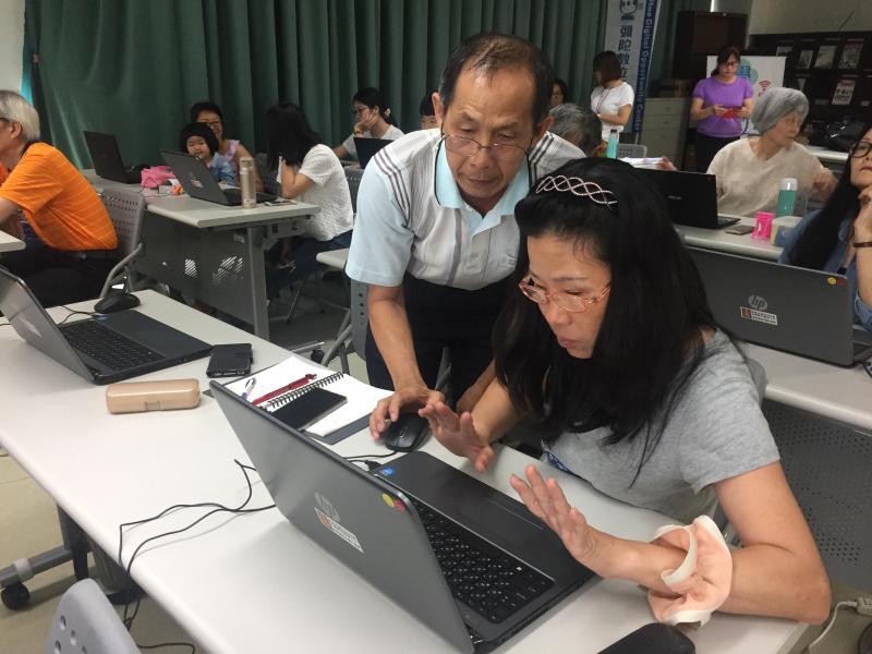 資深學員協助指導新手學員認識電腦操作
