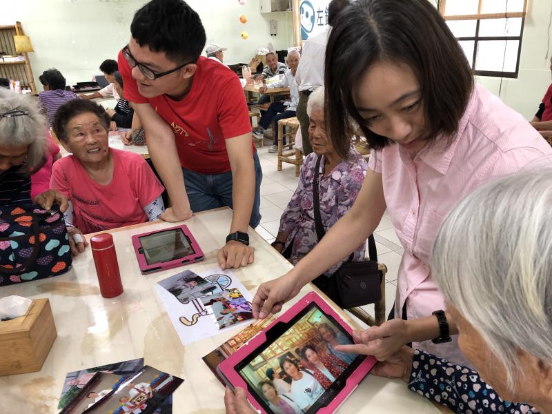 老師指導學員如何用平板把他們珍貴的照片拍下來變成電子檔方便運用及留存!