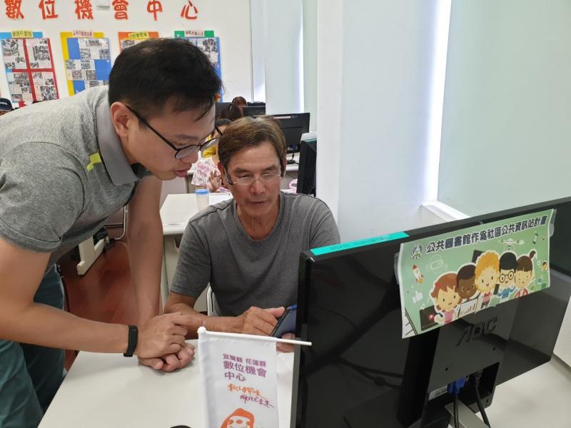 學員坐在電腦桌前，正在詢問講師關於網路設定的問題。