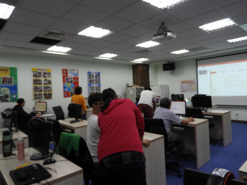 一位身穿紅衣的學員，與另一位身穿白衣的學員討論製作時遇到的困難。