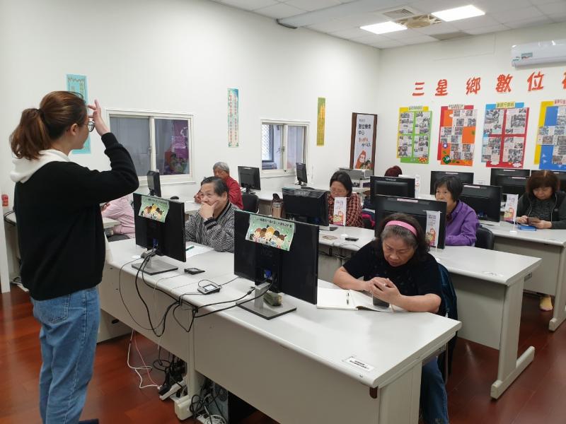 講師站在學員們的前方，觀察學生的使用狀況，解決他們的問題。